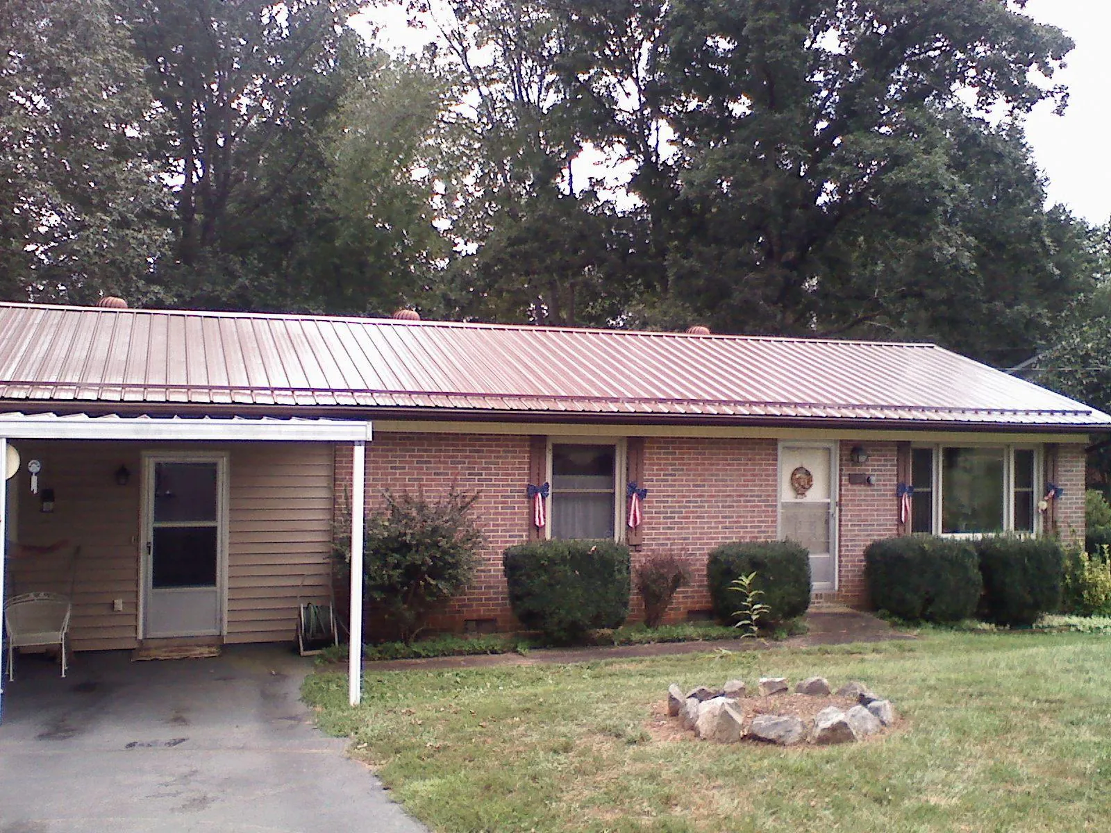Bronze metal roof and carport on a brick ranch home — Roof Repair work by our crew in Guin
