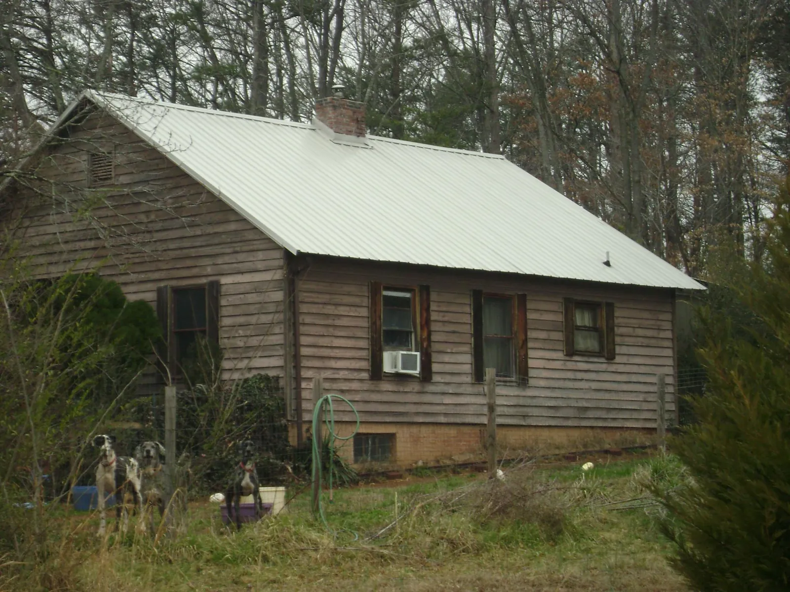 White metal roof on an old wood sided farmhouse, from a Metal Roof Installation job in Guin